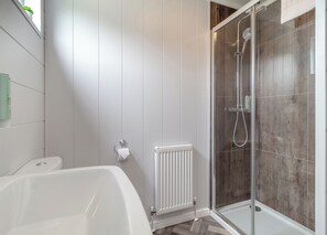 Ein modernes Badezimmer mit einer Duschkabine, einer weißen Badewanne und einer Toilette.