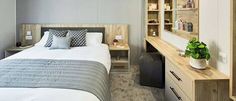Een moderne slaapkamer met een groot bed, nachtkastjes, een bureau met een plant en ingebouwde planken.