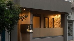 Un edificio moderno de dos pisos con techo plano, ventanas grandes y un balcón.