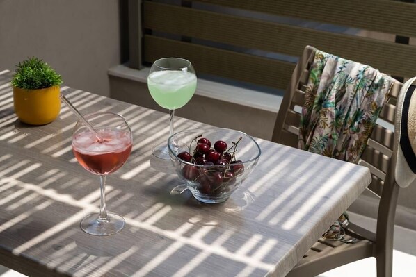 A table with two drinks, one in a glass and one in a bowl, and a small potted plant.