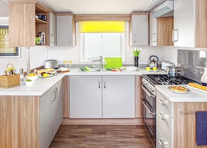 A modern kitchen with a stove, sink, and various appliances.