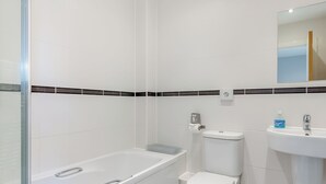 A modern bathroom with a glass shower enclosure, a toilet, and a sink.