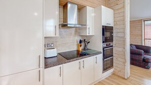 Eine moderne Küche mit weißen Schränken, einem Toaster, einem Messerblock und einer Mikrowelle.