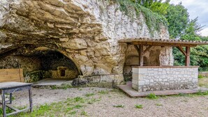 A cave-like structure with a stone bench and a small shelter.