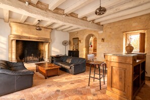 A cozy living room with a fireplace, leather sofa, and a wooden coffee table.