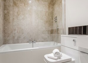 Un baño moderno con bañera, ducha y retrete.
