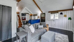 Ein modernes Wohnzimmer mit einem grauen Sofa, einem kleinen Tisch und einer blauen Akzentwand.