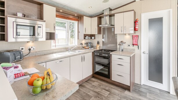 A modern kitchen with a microwave, toaster, stove, and sink.