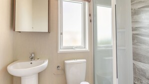 A bathroom with a sink, toilet, and shower.