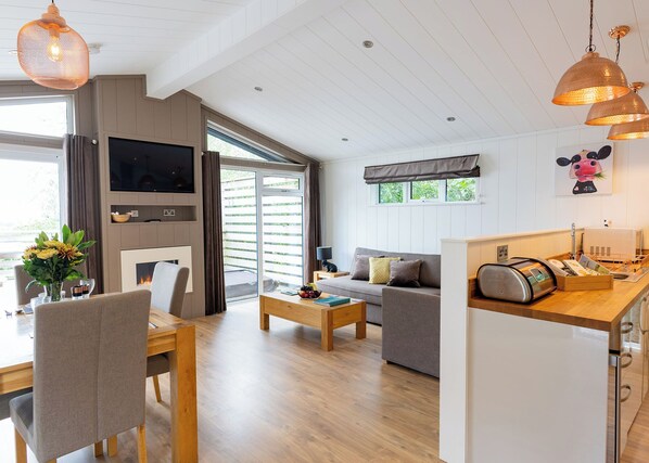 A modern living room with a sofa, coffee table, and dining area.
