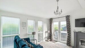 A living room with a sofa, a TV, and a fireplace. - Country Lodge Four Spa (Tintagel)