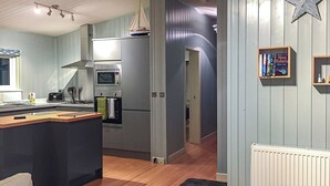 Une cuisine moderne dotée d’un îlot central, d’un four encastré et d’un four à micro-ondes.