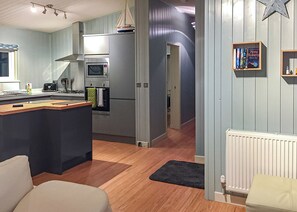 A modern kitchen with a central island, built-in oven, and microwave.