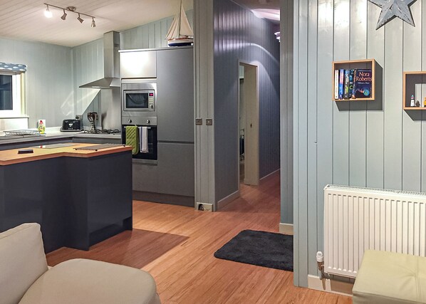 Een moderne keuken met een centraal eiland, een ingebouwde oven en een magnetron.