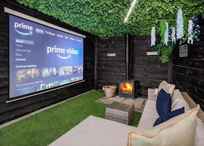 A cozy room with a large screen displaying a Prime Video interface, a fireplace, comfortable seating, and a green wall. - Stylish and contemporary lodge. (South Duffield, Nr York)