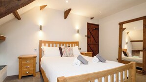 Une chambre à coucher avec un lit en bois, des tables de chevet, une armoire et un miroir.