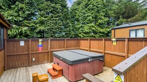 A wooden deck with a hot tub, wooden benches, and a wooden fence. - Comfortable and spacious lodge with two doubles and one with bunks. (Glenluce, Newton Stewart)
