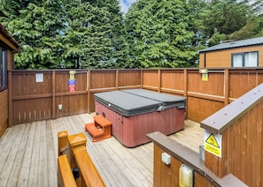 A wooden deck with a hot tub, wooden benches, and a wooden fence. - Comfortable and spacious lodge with two doubles and one with bunks. (Glenluce, Newton Stewart)