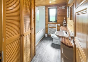 A wooden-paneled bathroom with a toilet, sink, and window. - Comfortable and spacious lodge with two doubles and one with bunks. (Glenluce, Newton Stewart)