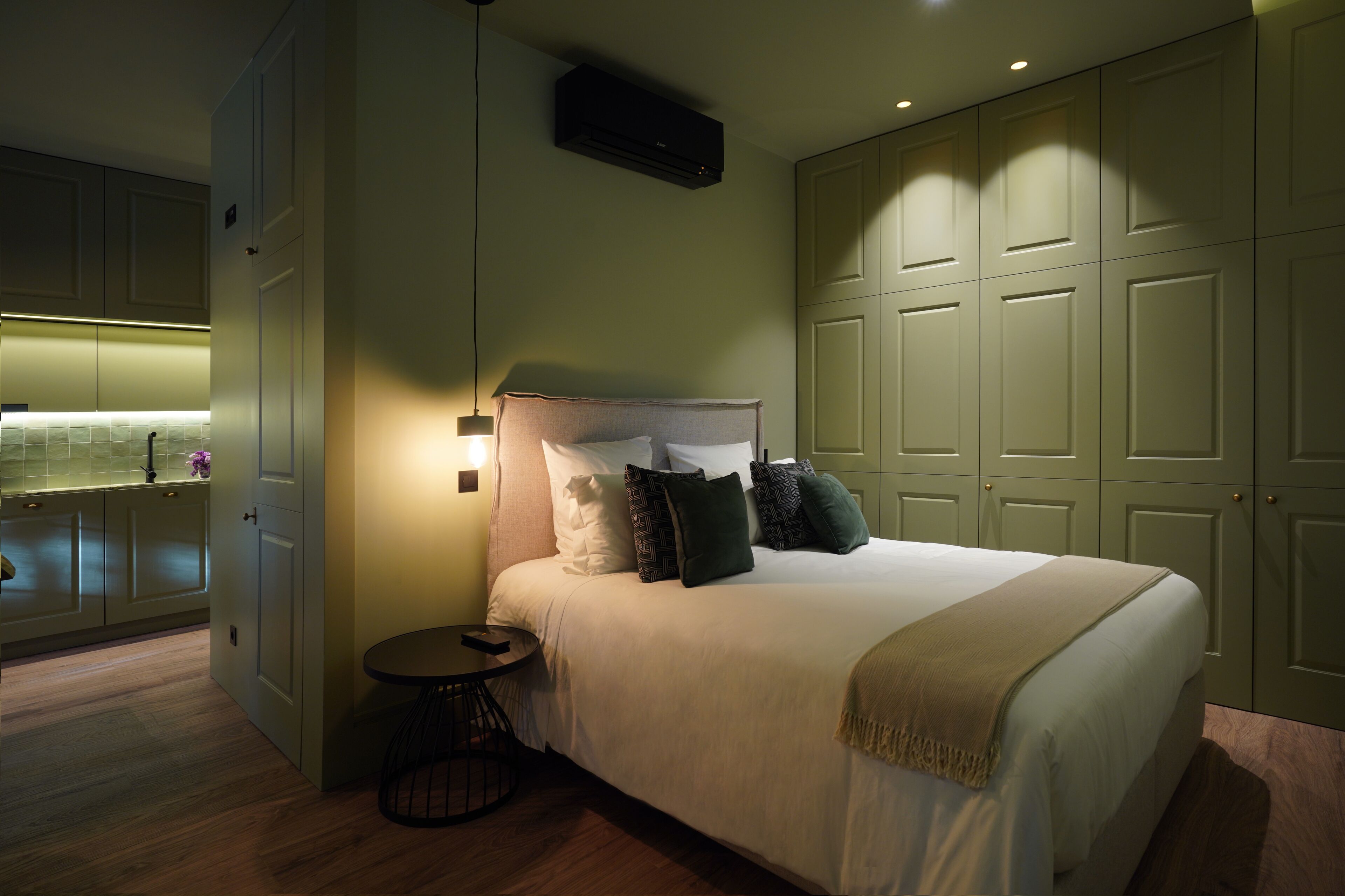 A bedroom with a bed, bedside table, and a wardrobe.