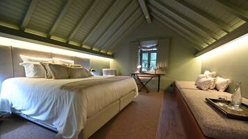 Ein Schlafzimmer mit einem großen Bett, einem Schreibtisch und einer Sitzecke.