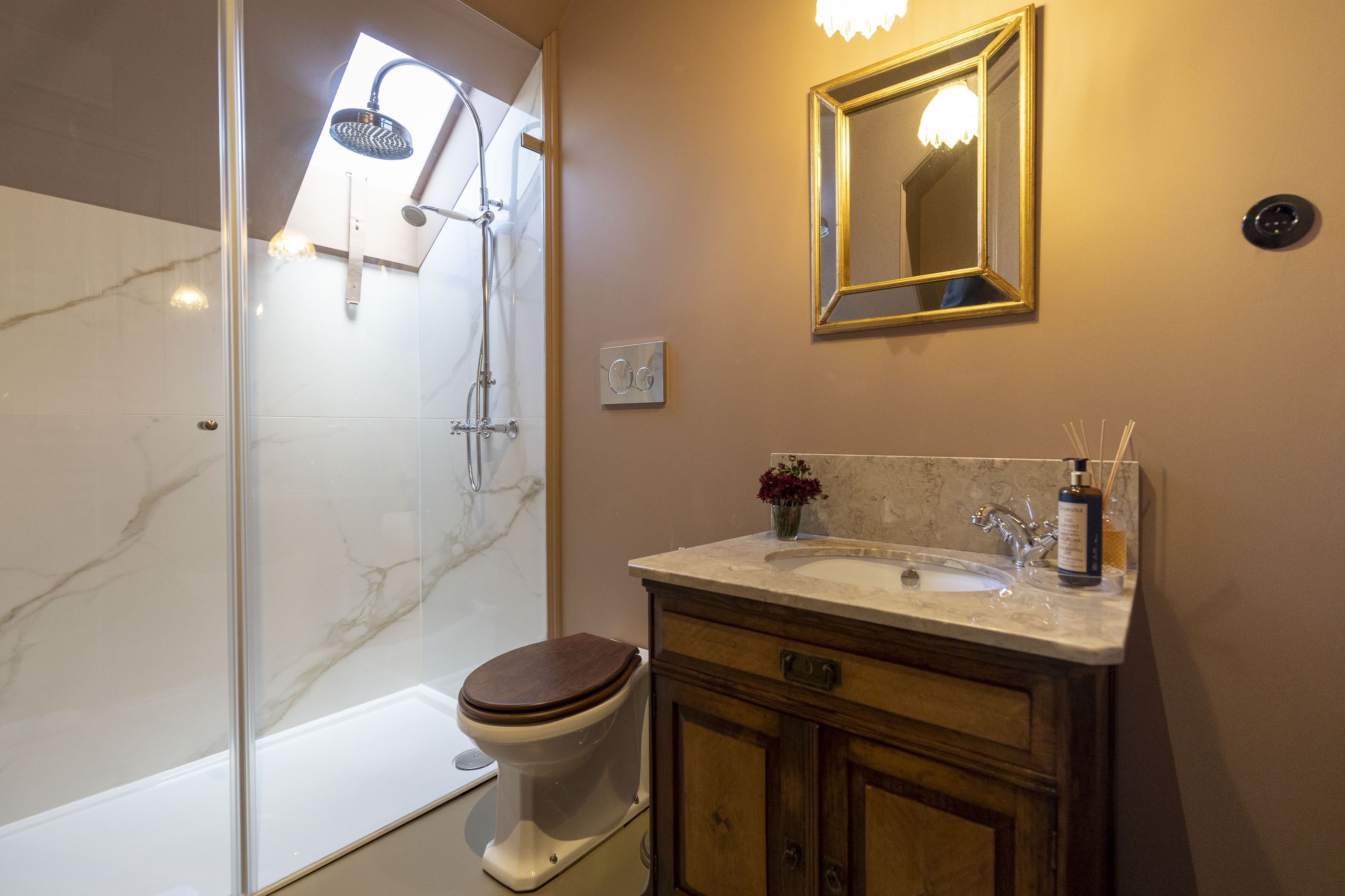 A bathroom with a shower, toilet, sink, and vanity.