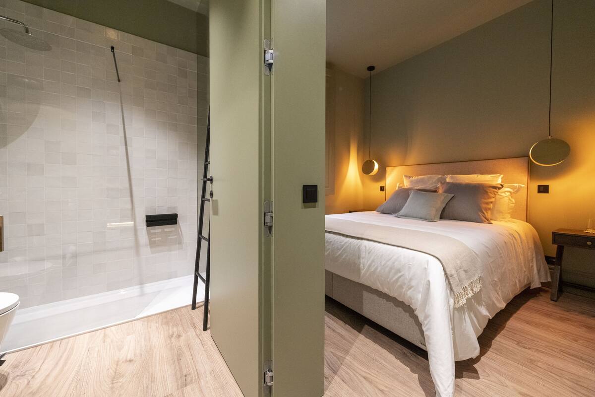 A modern bathroom with a glass shower enclosure and a separate toilet area.