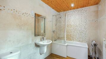 A bathroom with a wooden ceiling, a sink, a bathtub, and a shower.