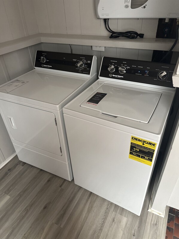 A laundry room with two Speed Queen washers and a dryer.