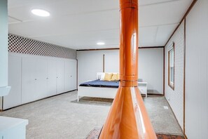 Ein Schlafzimmer mit einem Bett, einem weißen Kleiderschrank und einer großen, orangefarbenen Säule.