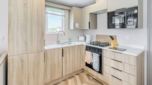 A modern kitchen with a built-in microwave, stove, and sink.