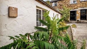 A white building with a wooden sign reading 'South Meadow.' - 2 bedroom accommodation in Watergate, Looe (Watergate, Looe)