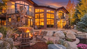 A large, multi-story building with a stone facade, large windows, and a fire pit area with outdoor seating. - Star Mountain Lodge💎23 Guests🏔️Grotto Waterfall🌊Theater🍿Game room🧖‍♀️Spa (Keystone)
