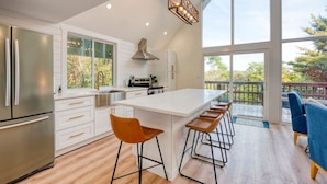 Una cocina moderna con una isla grande, electrodomésticos de acero inoxidable y vistas al exterior.