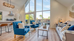 Un amplio espacio habitable con un gran ventanal, una cocina con electrodomésticos modernos y un rincón de estar acogedor.