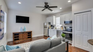 A modern living room with a gray sofa, wooden entertainment center, and a flat-screen TV. - 4.5mi to Augusta National & walkable downtown! (Augusta)