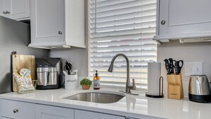 A modern kitchen with white cabinets, a stainless steel sink, a coffee maker, and a knife block. - 4.5mi to Augusta National & walkable downtown! (Augusta)