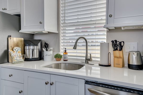 A modern kitchen with white cabinets, a stainless steel sink, a coffee maker, and a knife block. - 4.5mi to Augusta National & walkable downtown! (Augusta)