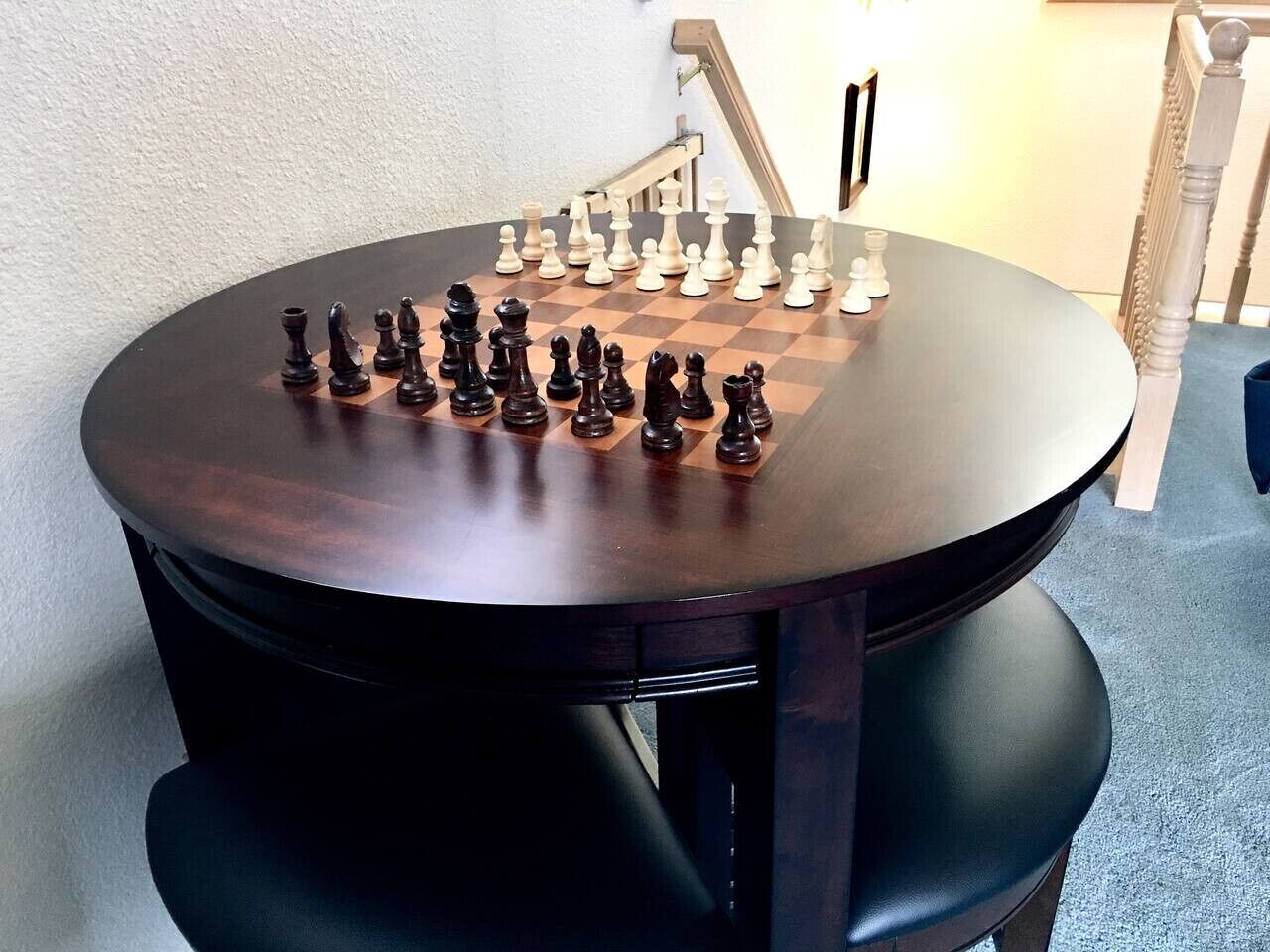 Een ronde houten tafel met een schaakbord erop.