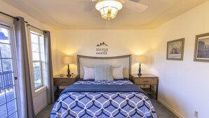 A bedroom with a bed, two bedside tables, a ceiling fan, and a wall-mounted sign. - Squirrel View - Hot tub/BBQ/Patio/Shuffle Board (Oakhurst)