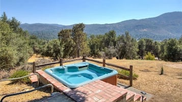 Un bain à remous dans un cadre naturel, avec vue sur les montagnes.