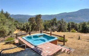 Un jacuzzi en un entorno natural con vistas a las montañas.