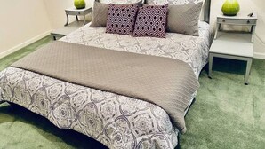 Una camera da letto con un letto, due comodini e un tavolino da notte.