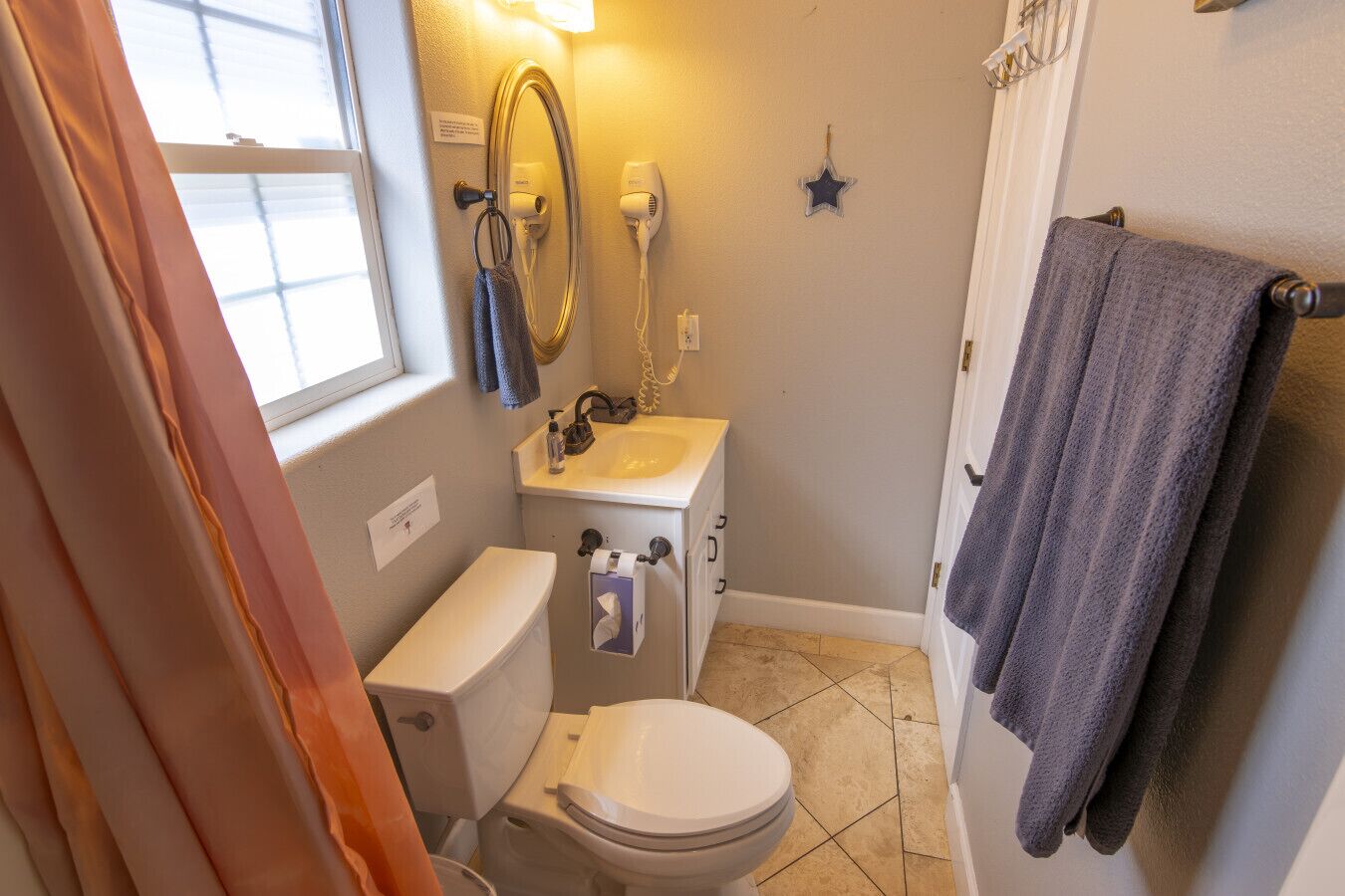 Une petite salle de bain équipée de toilettes, d’un lavabo et d’un sèche-cheveux.