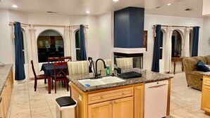Una cocina compacta con una isla central, armarios de madera y un lavavajillas integrado.