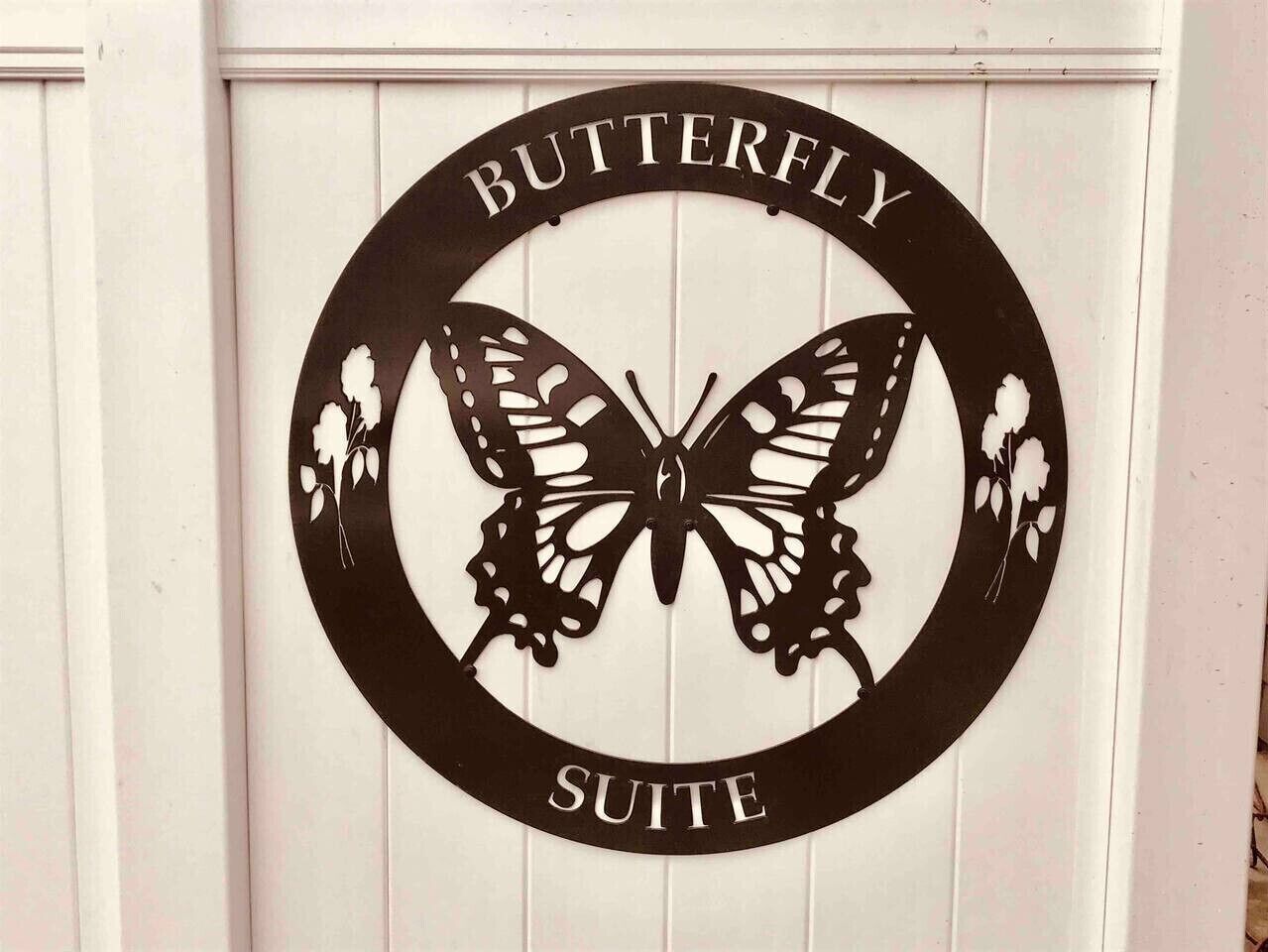 A sign with a butterfly design and the words "BUTTERFLY SUITE" on a white background.