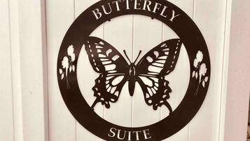 A sign with a butterfly design and the words "BUTTERFLY SUITE" on a white background.