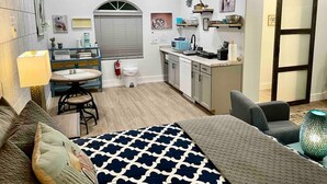Een knus verblijf met een kitchenette, een eethoek en een slaapkamer.
