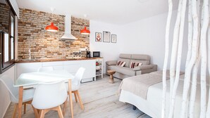 Un espacio habitable moderno y funcional con cocina, mesa de comedor y sofá.
