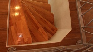 Una escalera de madera con barandillas de metal que conduce a un piso superior.